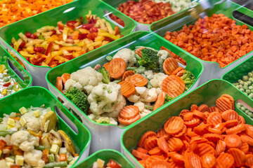 A variety of frozen foods lie in white cups.