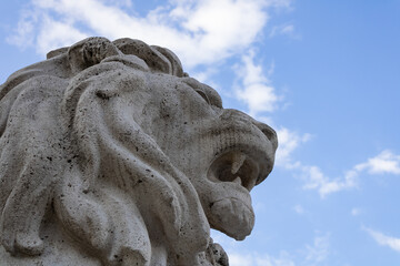 Obraz premium A stone statue of a lion with the sky behind it