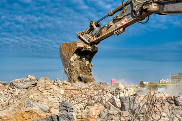 Fototapeta premium An excavator spills soil out of a bucket.