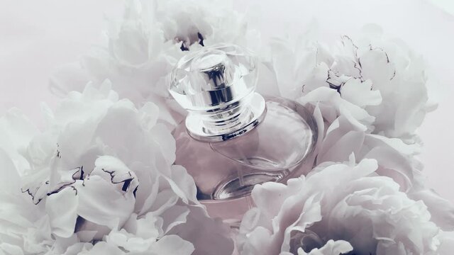 White perfume bottle with peony flowers, chic fragrance scent as luxury cosmetic, fashion and beauty product background, stock footage