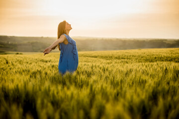 Young pregnant woman in the field