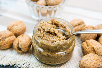 jar of raw organic walnut butter or paste and fresh nuts in bowl