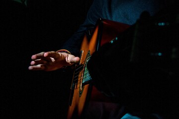 Closeup shot of a musician playing guitar under the lights