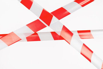 Red and white restrictive tape on a white background. The tape is crossed, restriction