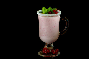 Red current milkshake in high glass. Black background.