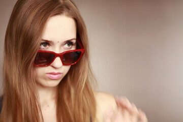 Naklejka premium Girl in glasses. Girl portrait in red glasses. Beautiful young curious woman. Woman watching.