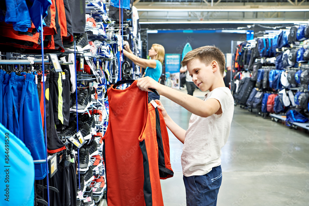 Wall mural Boy with red t-shirt in basketball sport shop