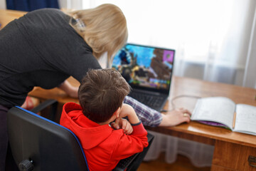 Mother turning off computer for computer addicted little gamer kid - 364692163