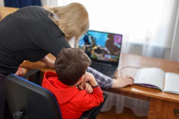 Fotobehang Mother turning off computer for computer addicted little gamer kid © sakkmesterke