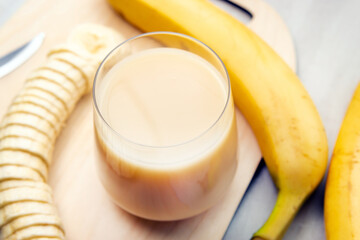 Banana smoothie, banana juice. Bananas on a gray light background, selective focus