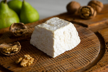 Obraz na płótnie Canvas Premium organic goat cheese on a rustic wooden cheese maker.