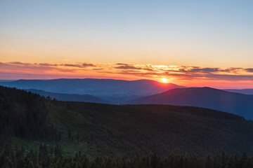 Sunset with colorful sky from Dlouhe strane hill in Jeseniky mountains in Czech republic