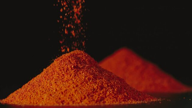 Red pepper powder pouring on a table, Close Up, slow motion