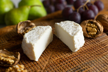 Premium organic goat cheese  on a rustic wooden cheese maker.