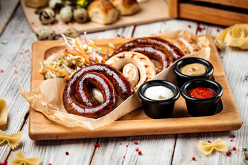 Fototapeta na wymiar Grilled sausages with sauerkraut and sauces