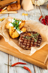 Ribeye beef steak with baked potatoes  sour cream