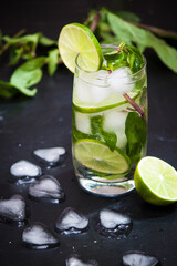 Summer coctail mojito with ice, mint, lime on a grey background. Copy space.