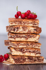 Sweet cake with cocoa powder zebra with berries and chocolate on dark wooden background. Vertical.