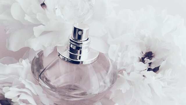 White perfume bottle with peony flowers, chic fragrance scent as luxury cosmetic, fashion and beauty product background, stock footage