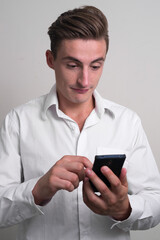 Portrait of young handsome businessman using phone