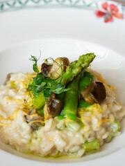 Risotto with snails and asparagus. The dish is decorated with pea microgreens. The asparagus sprouts lie on top of the dish. Food styling. Traditional Italian and French food. 