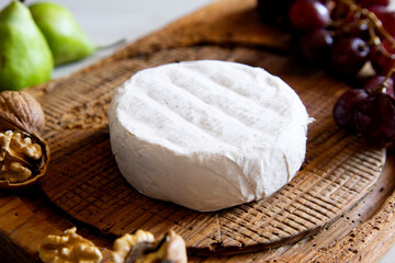 Premium organic goat cheese  on a rustic wooden cheese maker.