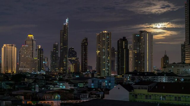 Timelapse of Bangkok Skyline during supermoon at night time.