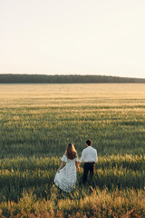 Beautiful couple in nature in boho style. Wedding in European style fine art at sunset.