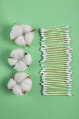 Flat lay with natural ear sticks and cotton bolls on a light green background. lifestyle concept. zero waste, plastic free items. stop plastic pollution. reuse, reduce