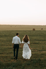 Beautiful couple in nature in boho style. Wedding in European style fine art at sunset.