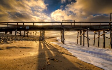 Long exposure shot of a pier on the beach in California during sunset © Rolf Nachbar/Wirestock