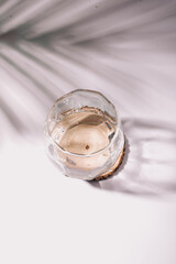 An empty glass in a wooden shadow on a white background