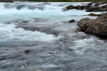 Rapids at the confluence of blue Baker river and grey Neff river, Pan-American Highway between...