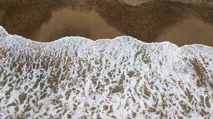 A wave coming over the sandy beach in the uk coast