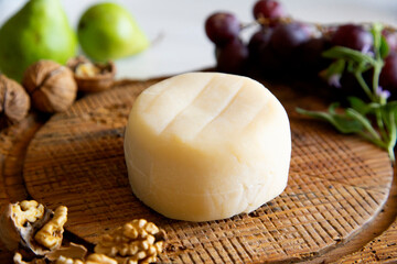 Premium organic goat cheese  on a rustic wooden cheese maker.