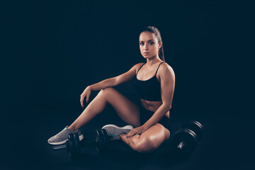 Obraz premium Portrait of concentrated lady sit wear sneakers hair brunette isolated over black background