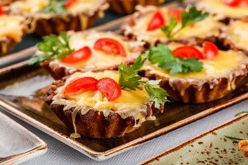 Delicious appetizers in tart with  cheese and meat in plate on banquet table. Catering food, canape and snacks, close up
