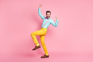 Full length photo of crazy overjoyed handsome guy trend clothes raise fists hands up hooray wear...