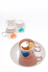 A mug of lemon tea and a few inverted cups