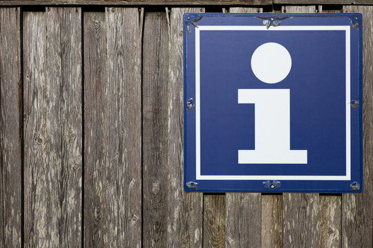 Holzwand mit einem Schild "I" Infotafel