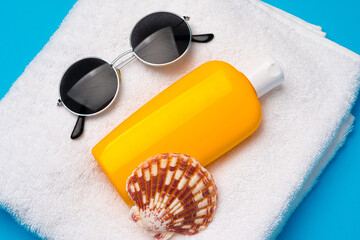 Sunglasses and sunblock cream close up on paper background