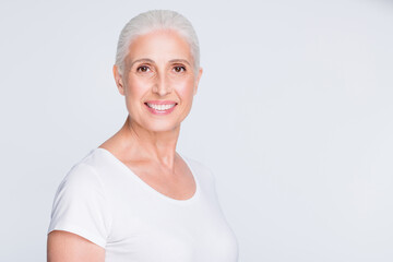 Portrait of charming old lady looking at camera having toothy smile isolated over white background