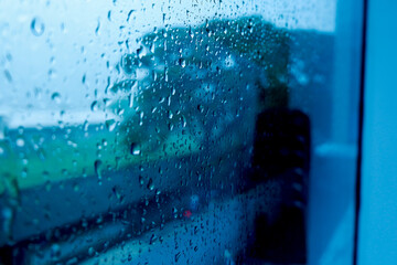 Raindrops outside the glass background window
