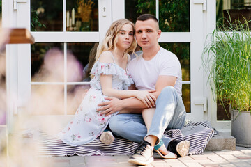 couple of lovers sitting in garden in backyard.