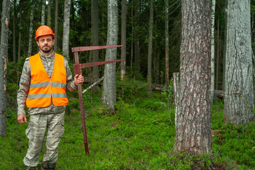 Forest worker makes a taxation of forest stands. Forester in work clothes. Real people work.