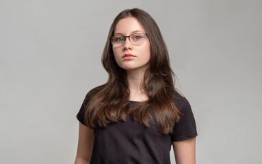 Confident woman portrait. Female power. Strong smart lady in eyeglasses isolated on gray background. Feminism protest. Skeptic activist. Gender equality.