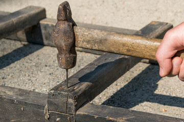 Hammer a nail into a wooden structure