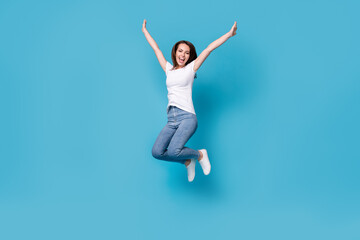 Full length body size view of her she attractive lovely slim skinny glad lucky cheerful cheery girl jumping rising hands up having fun holiday isolated bright vivid shine vibrant blue color background