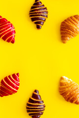 Frame of croissants - fresh bakery on yellow background. Top view