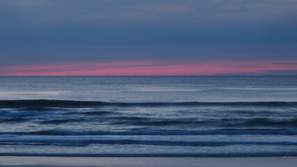 Obraz premium Pose longue créant un effet de filé sur les vagues, pendant l'heure bleue
